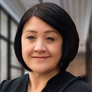 Headshot of Emma Lloyd in a floral top looking directly at the camera